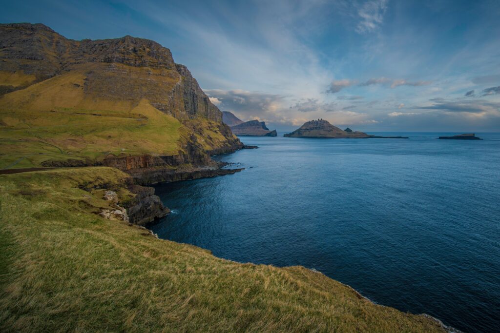 Captivating view of mossy cliffs overlooking the Atlantic Ocean in the Faroe Islands.